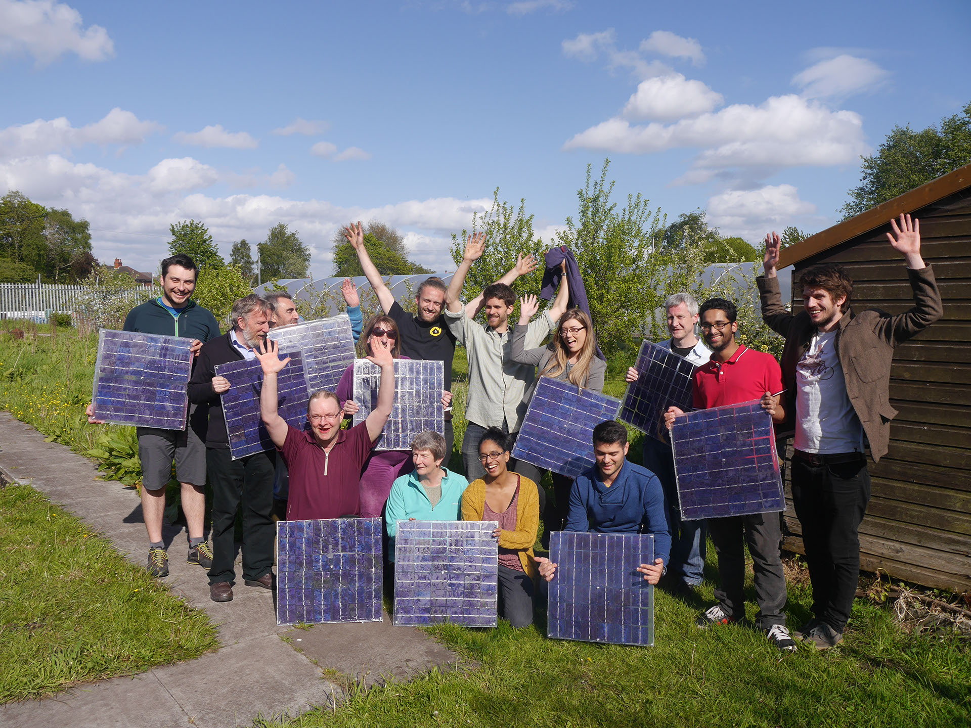 A group of people holding solar panels.