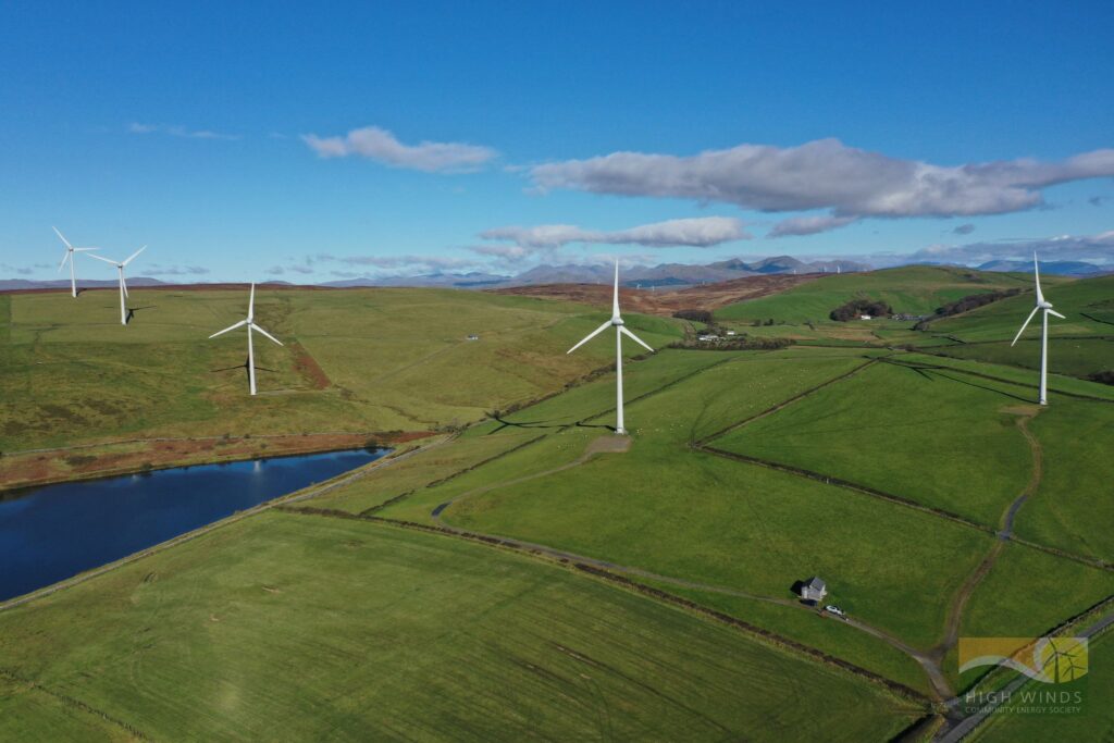 Photograph taken from the air of five wind turbines in green fields