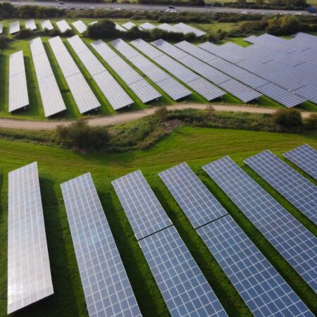 multiple solar panels in a green field
