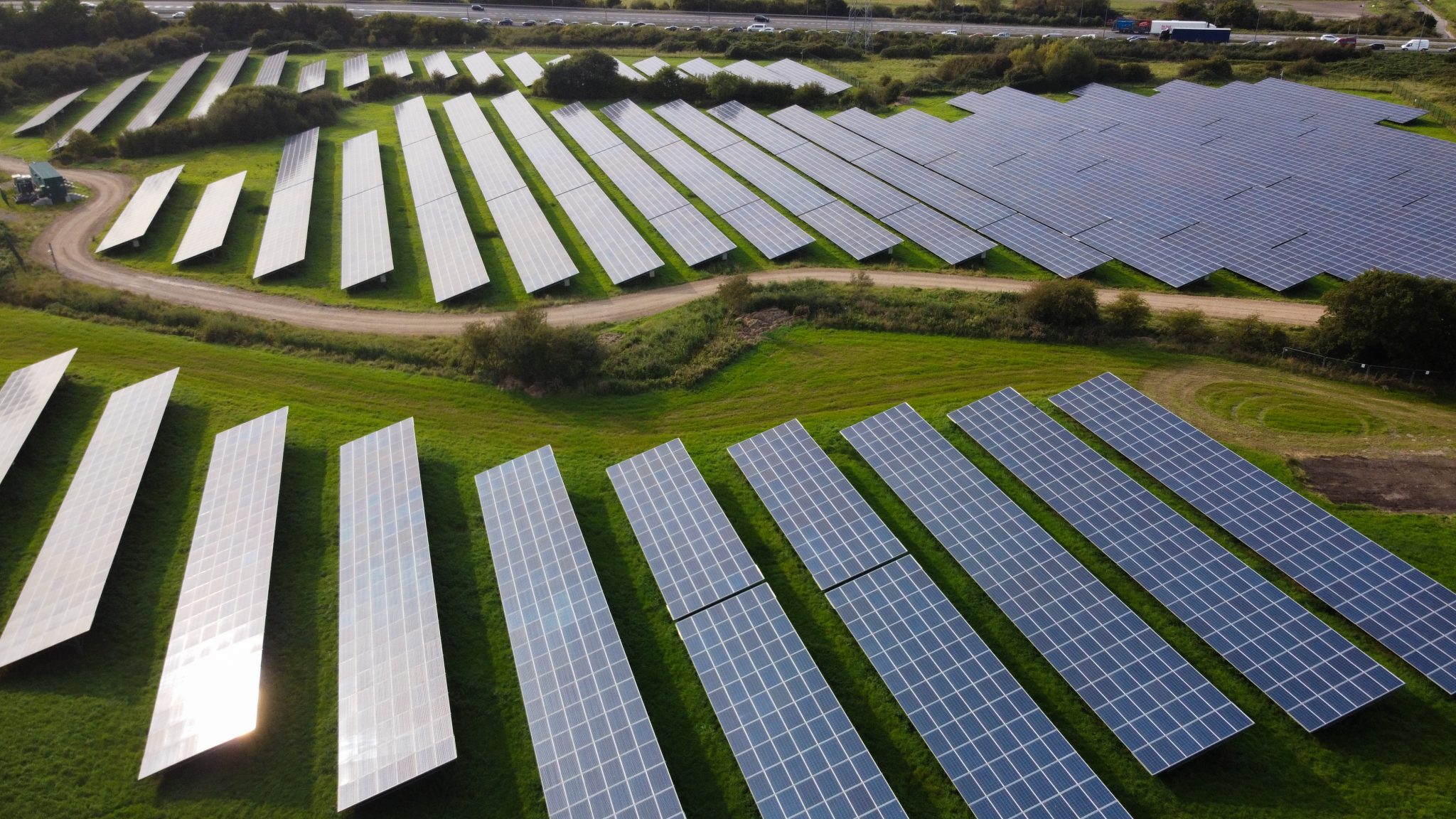 multiple solar panels in a green field