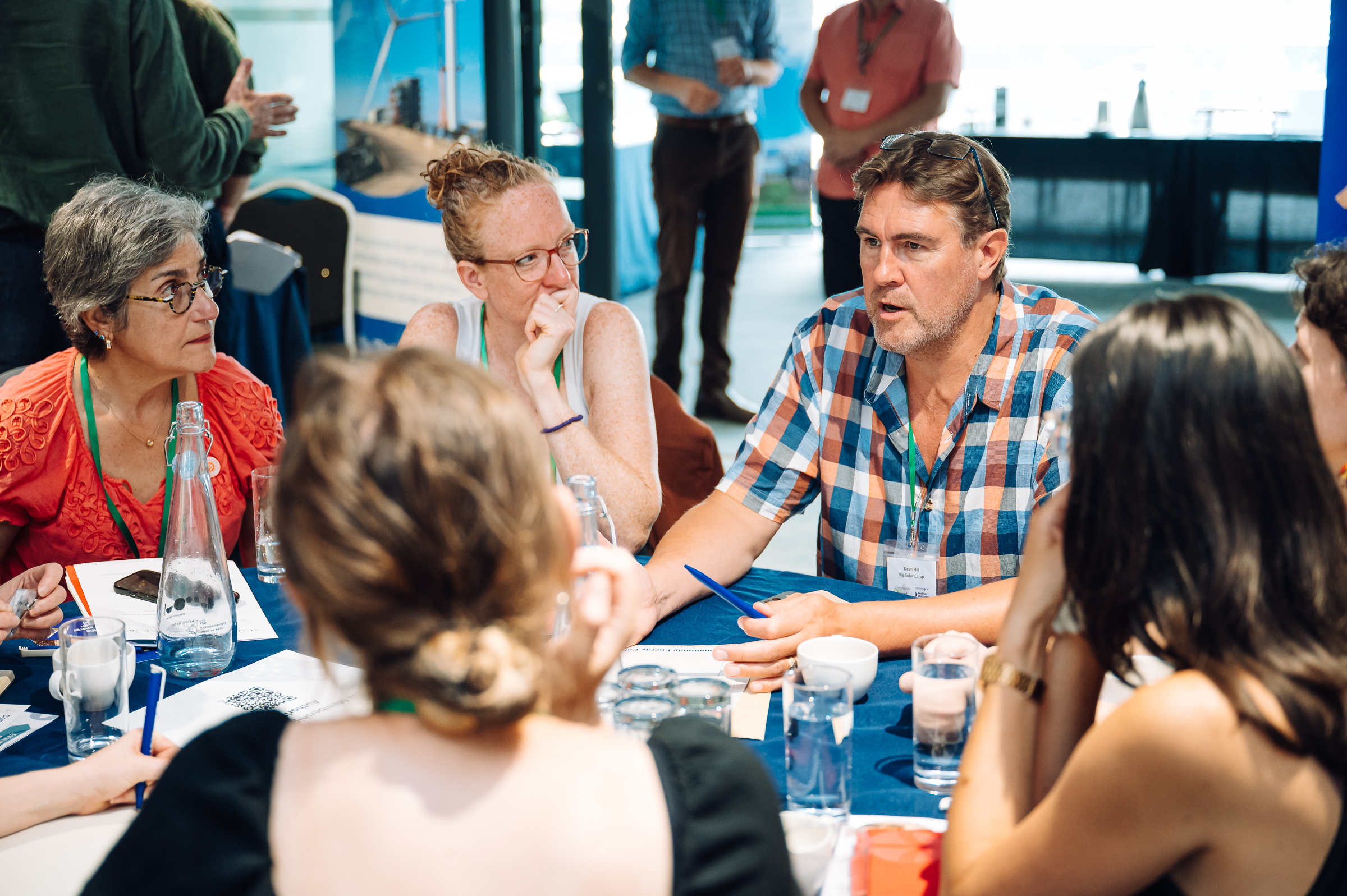 people sit at a round table at a conversation, mid discussion