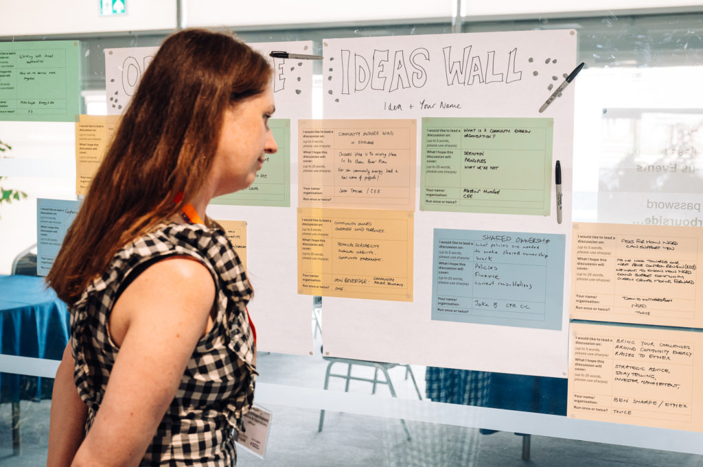 a person looks at posters attached to an ideas wall