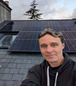 a person takes a selfie of themselves with solar panels on a roof