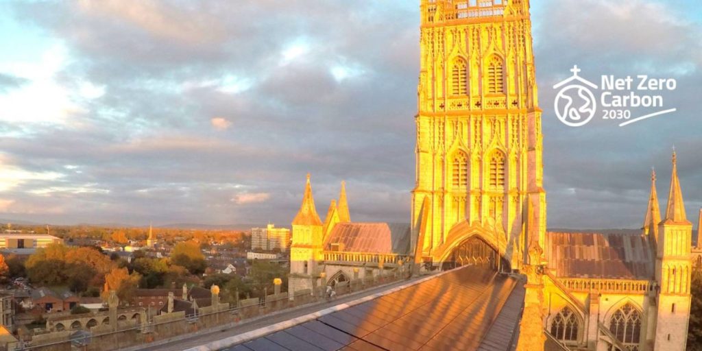 a large church with solar panels on it is golden in the setting sun