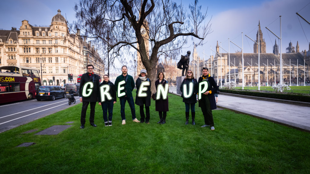 People wear lit up letters spelling out 'Green Up'