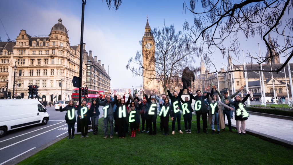 a group of people wearing letters spelling out 'Up the Energy with a map of the UK'